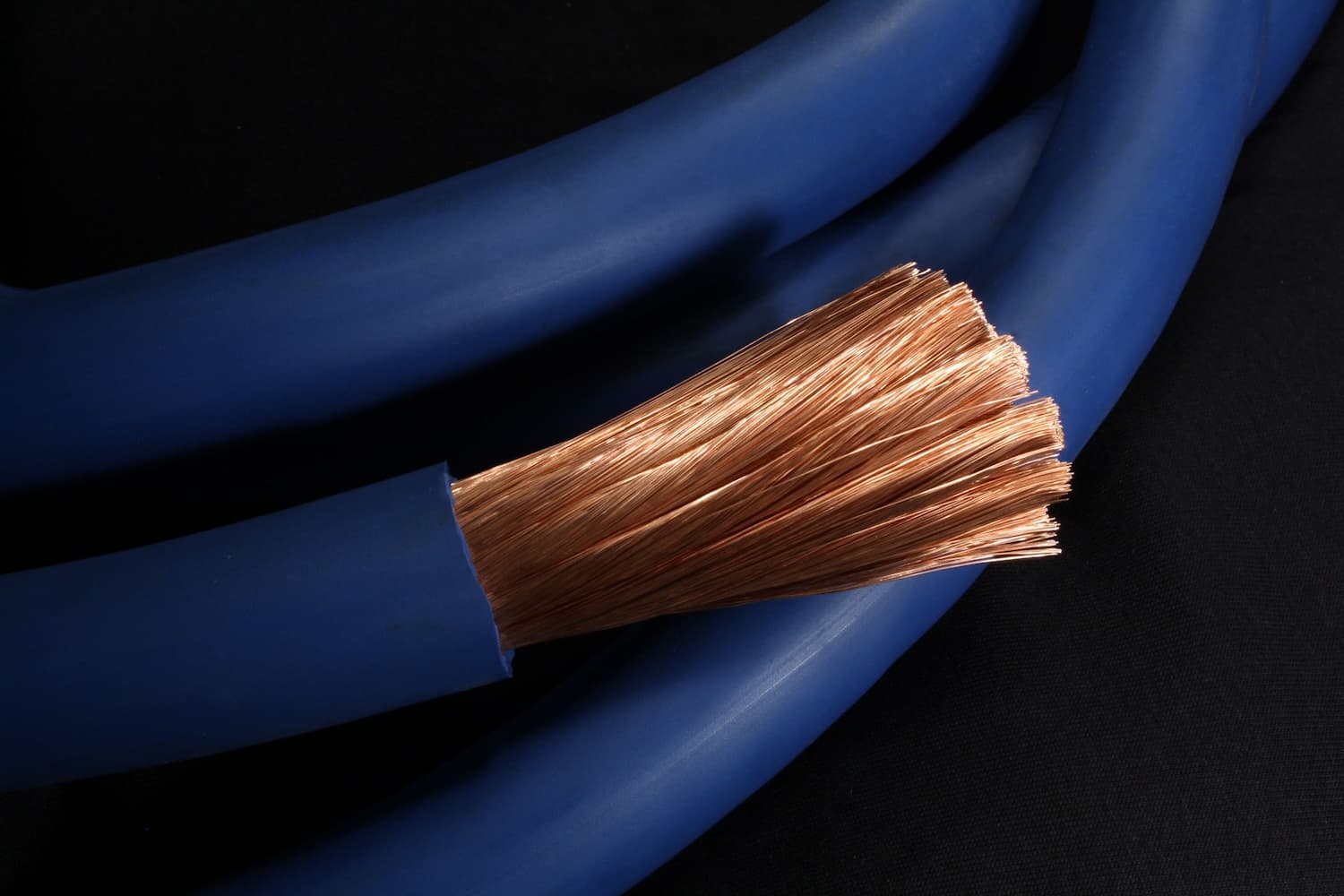 A cut end of 500 MCM Arctic Ultraflex Blue beside coils of finished blue cable