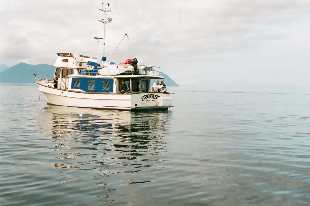A fishing boat at anchor on calm Alaskan water