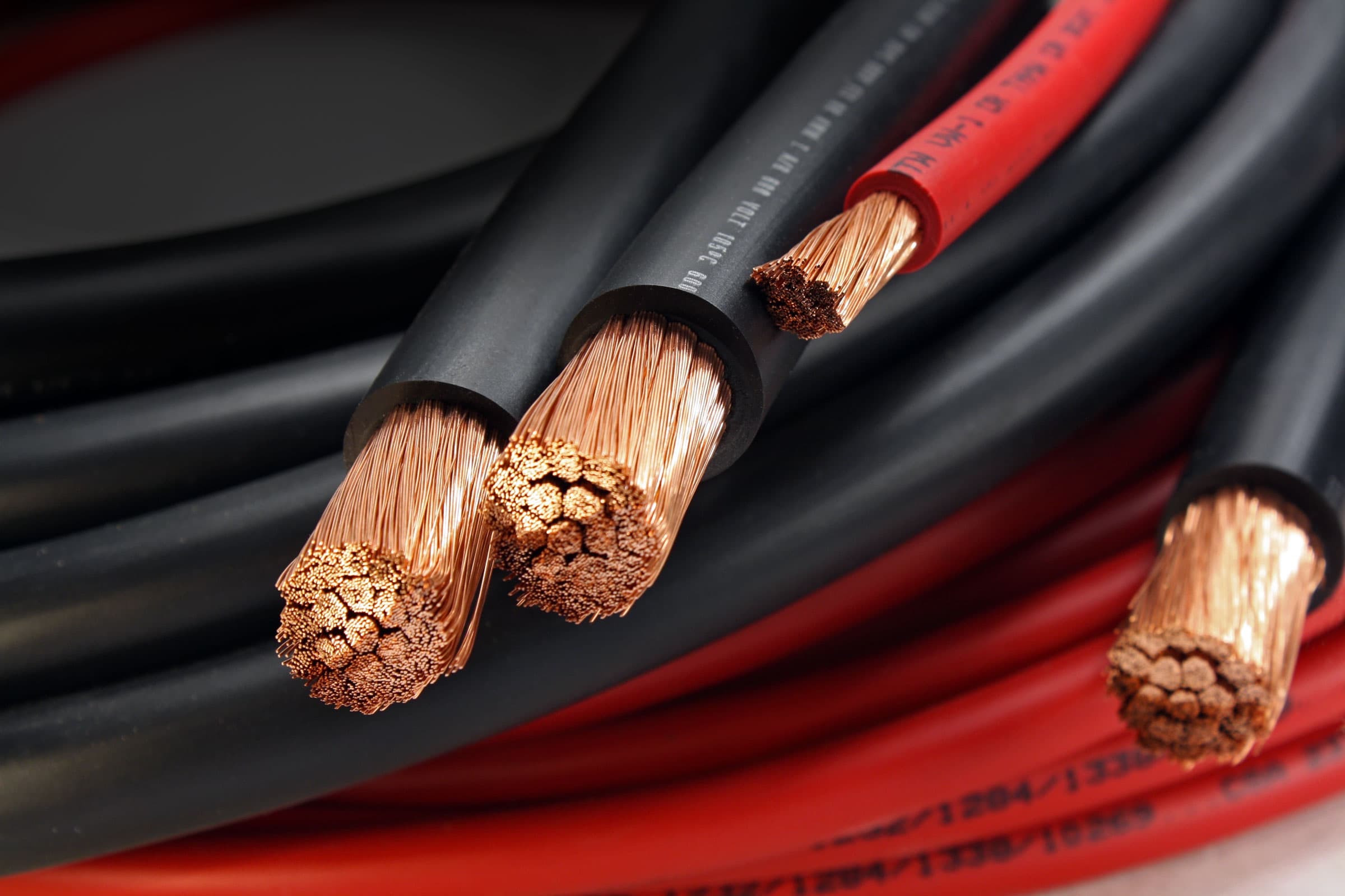 Cut ends of black and red multi-listed flexible wire showing fine copper stranding
