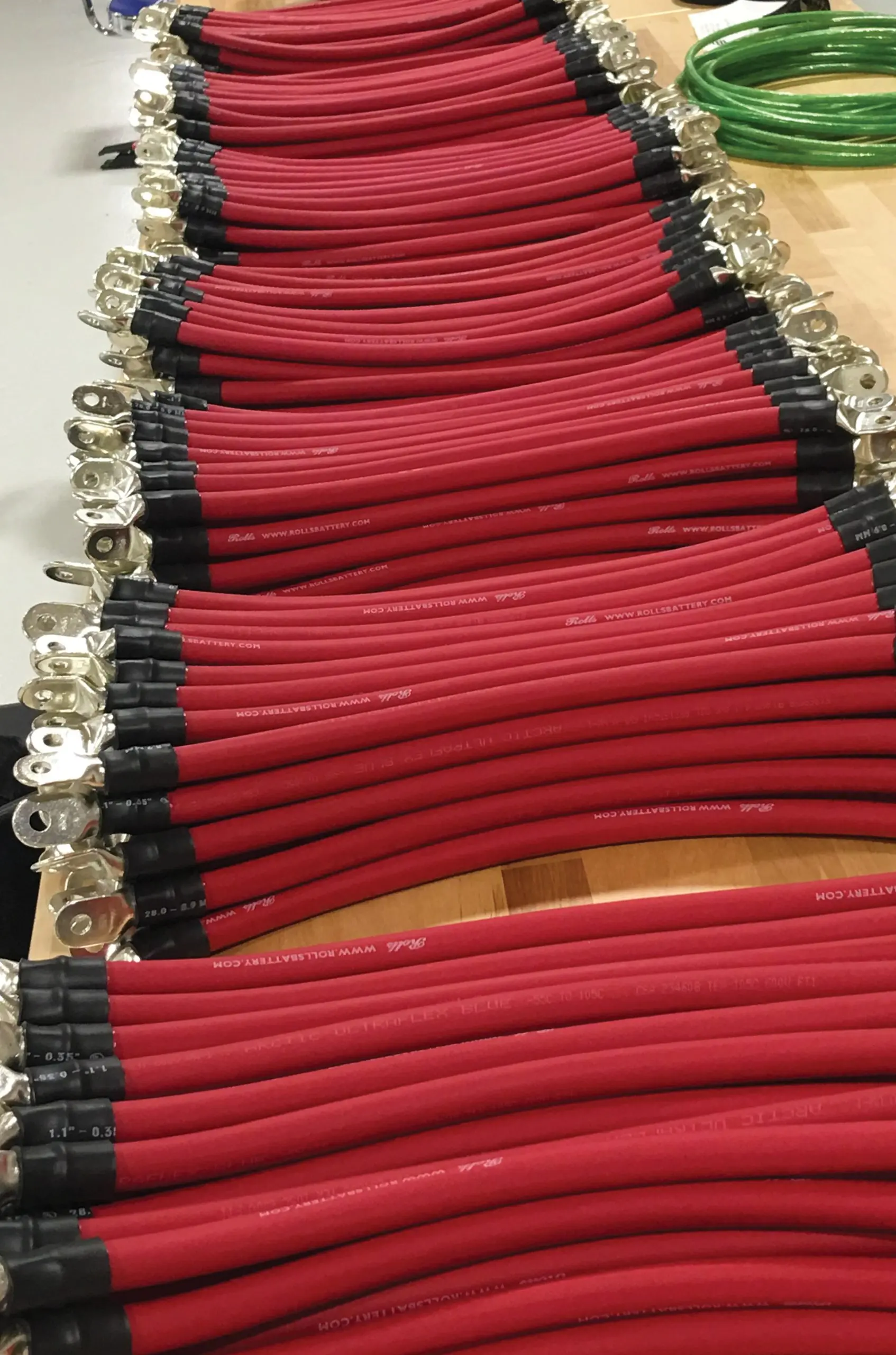 Private label battery cables stacked on a bench, customer legend printed on the jackets