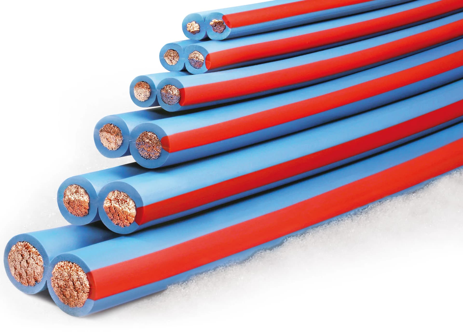 Arctic Superflex Blue in six stocked sizes, stacked and cross-sectioned on snow